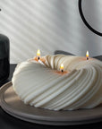 A stylized photo of Serene, 3-wick sculptural candle. 